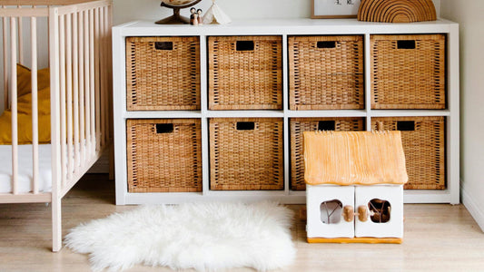 A nursery with a white storage shelf and woven baskets, a wooden dollhouse, and a cozy fur rug – 5 Tips for Organizing Toys and Keeping Your Home Tidy by myHelestia.