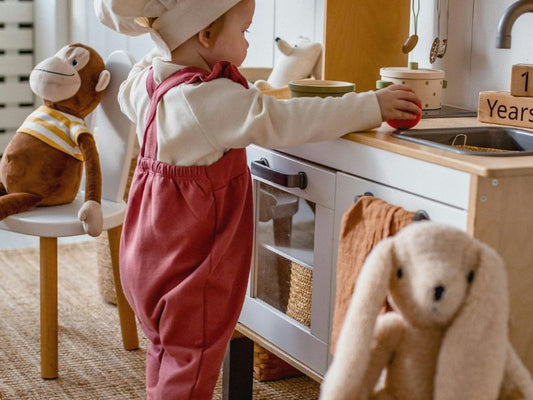 child playing in a play corner modelled as a kitchen